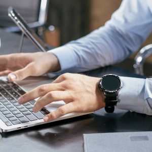 A person typing on a laptop at a desk, working through online training