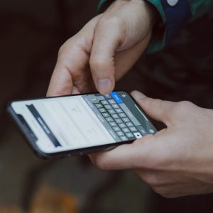 Person using a smartphone with a softly blurred background, browsing on a mobile
